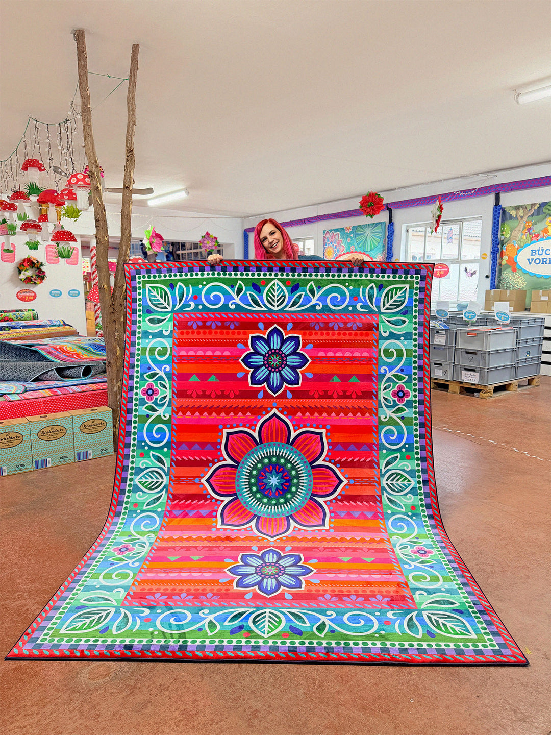 Superweicher Teppich im Design von Bine Brändle mit dem Motiv Jasmin in Rot, lebendig und dekorativ gestaltet.

